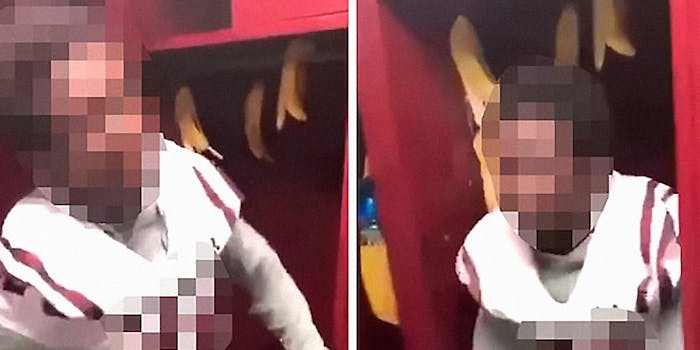 A football player with face blurred in a locker with bananas hanging in it.