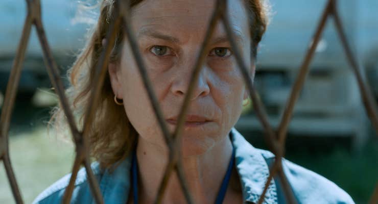 woman staring behind fence