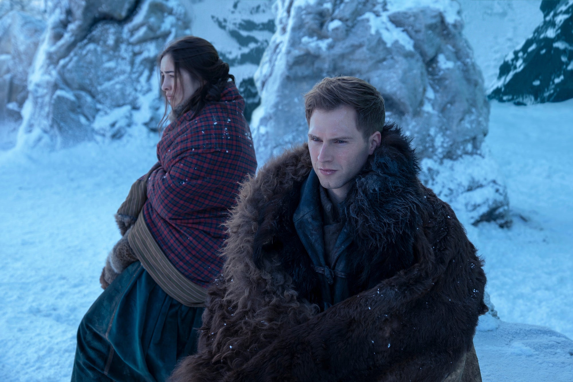 two people huddled in clothes to keep warm