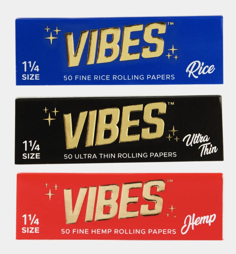 VIBES Rice Papers in blue packaging, Vibes ultra thin papers in black packaging and VIBES hemp rolling papers in red packaging all feature a gold logo that reads 'VIBES'