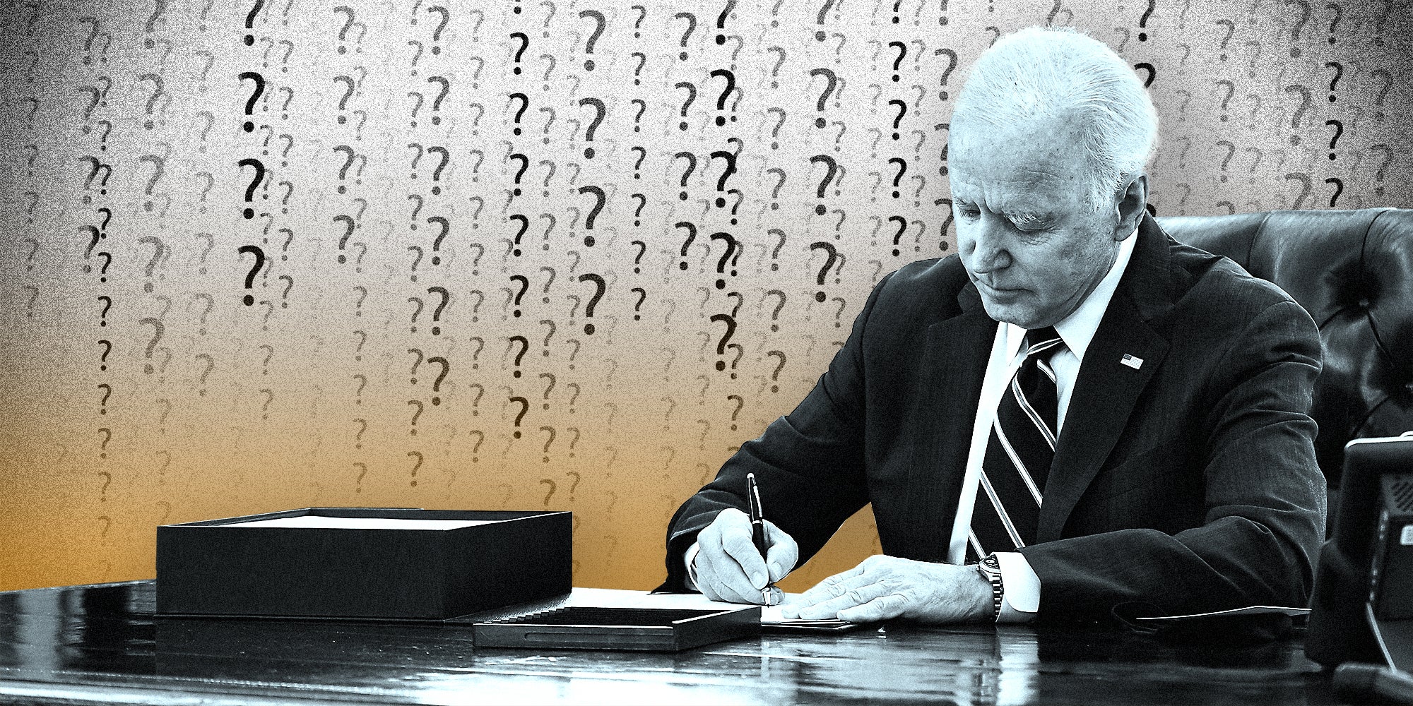 President Joe Biden signing a paper on a desk.