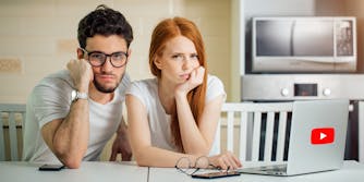 Upset couple in front of laptop with YouTube logo