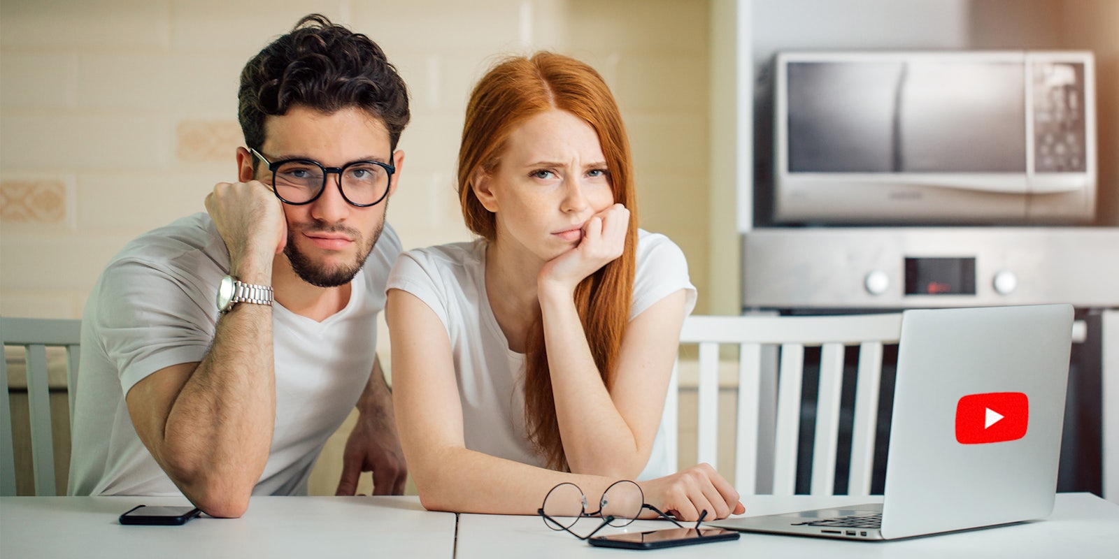 Upset couple in front of laptop with YouTube logo