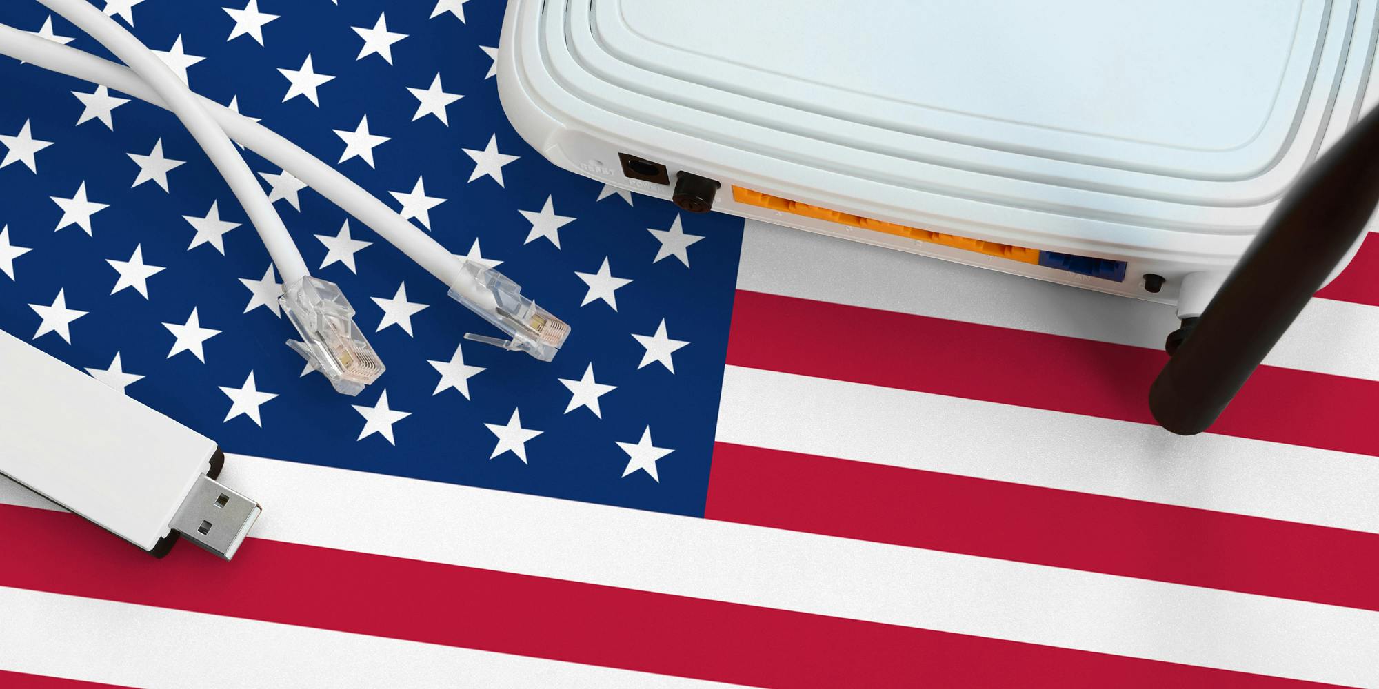 A broadband router, ethernet cables, and USB stick lying on top of an American flag.