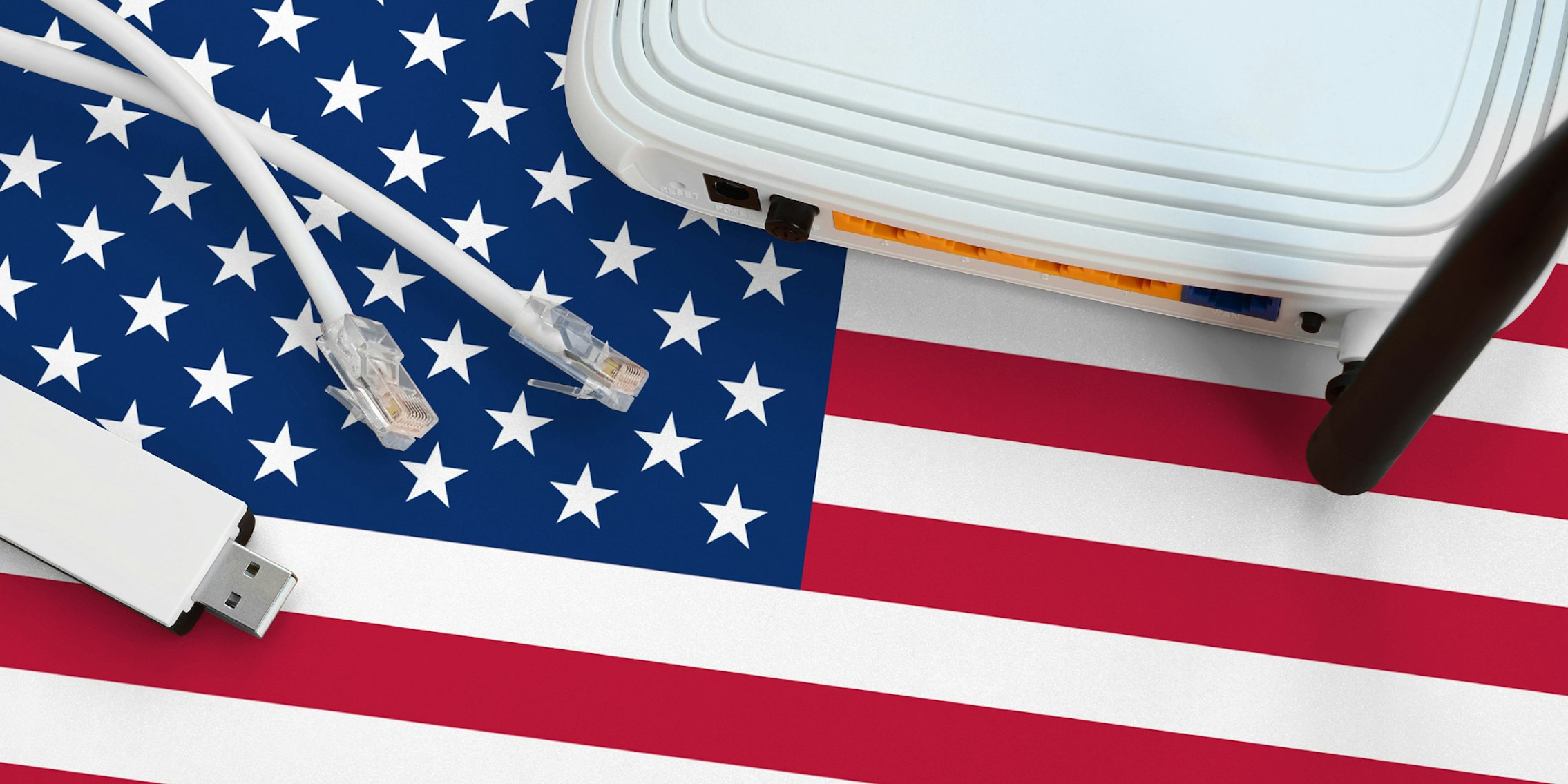 A broadband router, ethernet cables, and USB stick lying on top of an American flag.