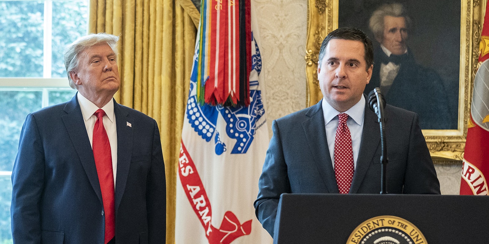 Devin Nunes speaking at a podium at the White House. Former President Donald Trump stands behind him.