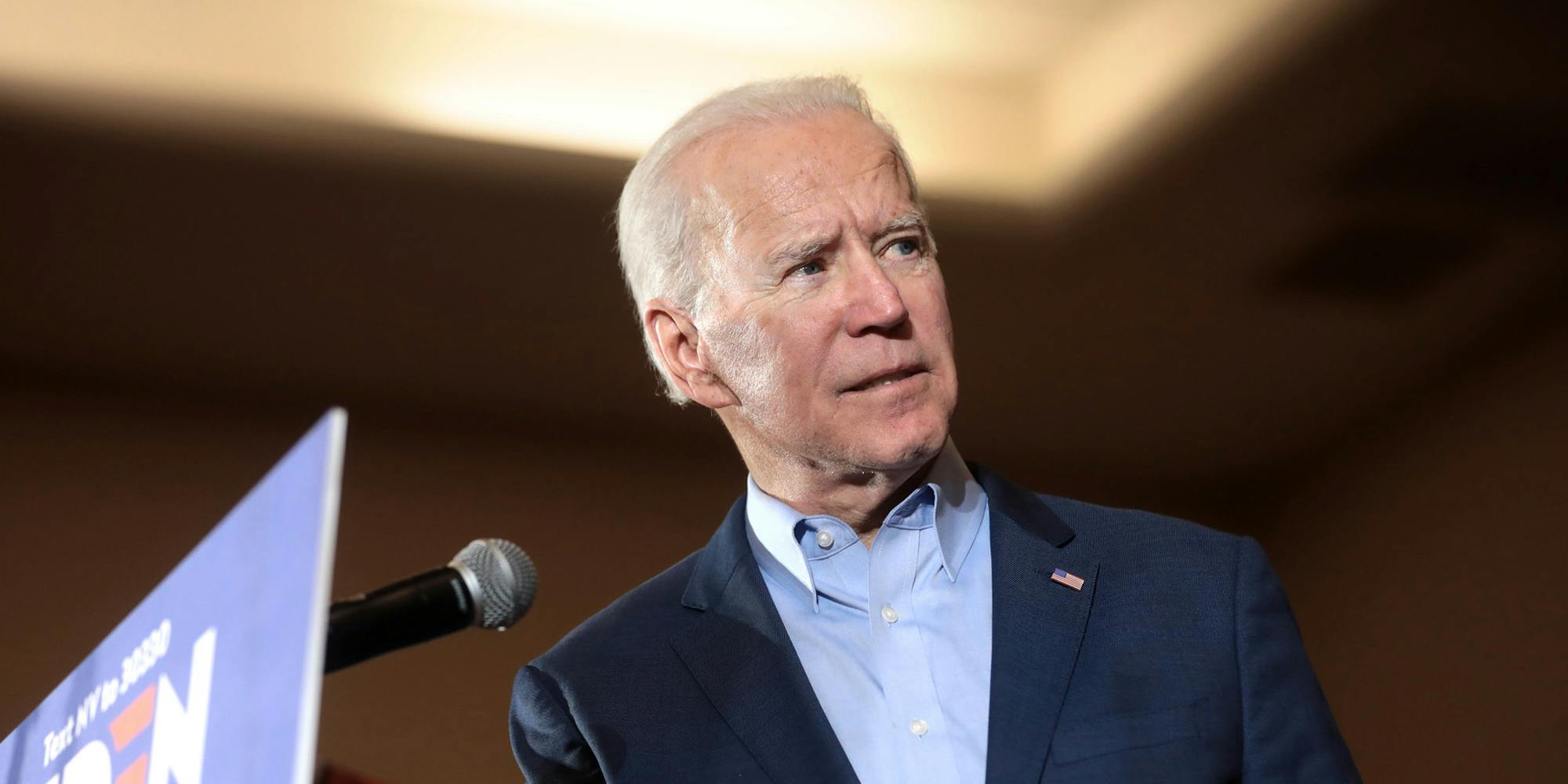 President Joe Biden speaking at a podium and looking off to the right of the screen.