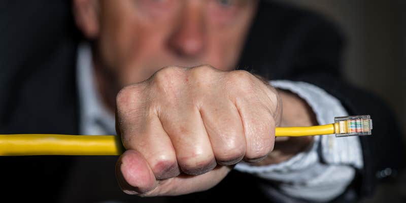 A man holding onto an ethernet wire.