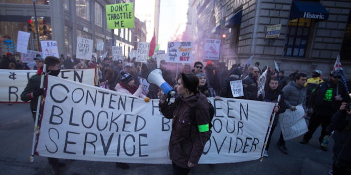 Net neutrality supporters protesting and holding signs that say 'content blocked.'