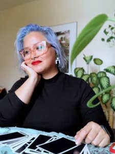 charm torres sits at a table with her tarot cards