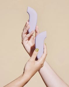 two Aer vibrators intertwined in someones hands.