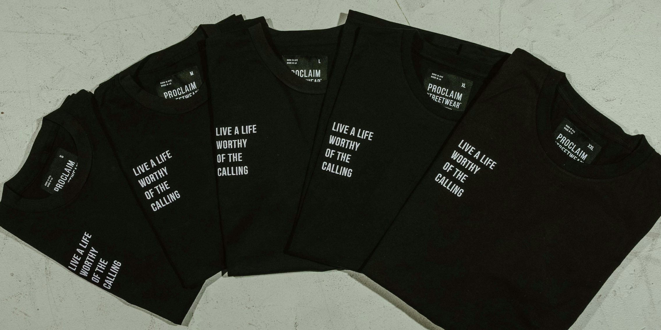black t-shirts that read 'live a life worthy of the calling' in small white letters