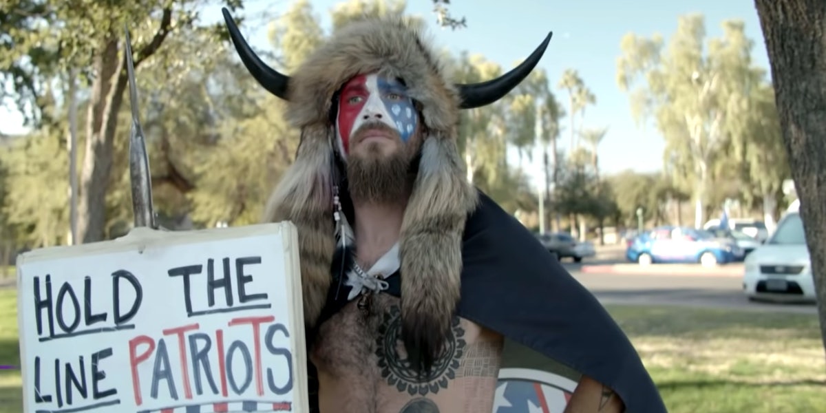 A man at a protest wearing horns, he is known as the QAnon Shaman.