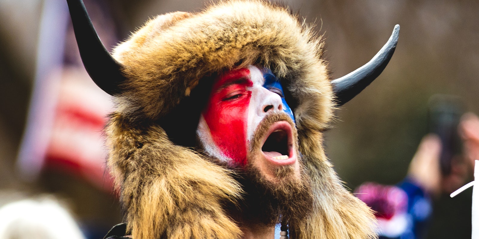 Jake Angeli, the 'Qanon Shaman' in red white and blue face paint and headdress.