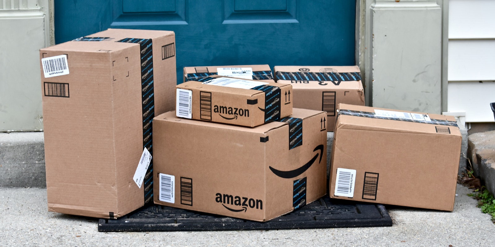 A group of Amazon boxes outside of someone's front door.