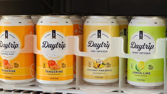 cans of the CBD drink Daytrip sit in a fridge dividers
