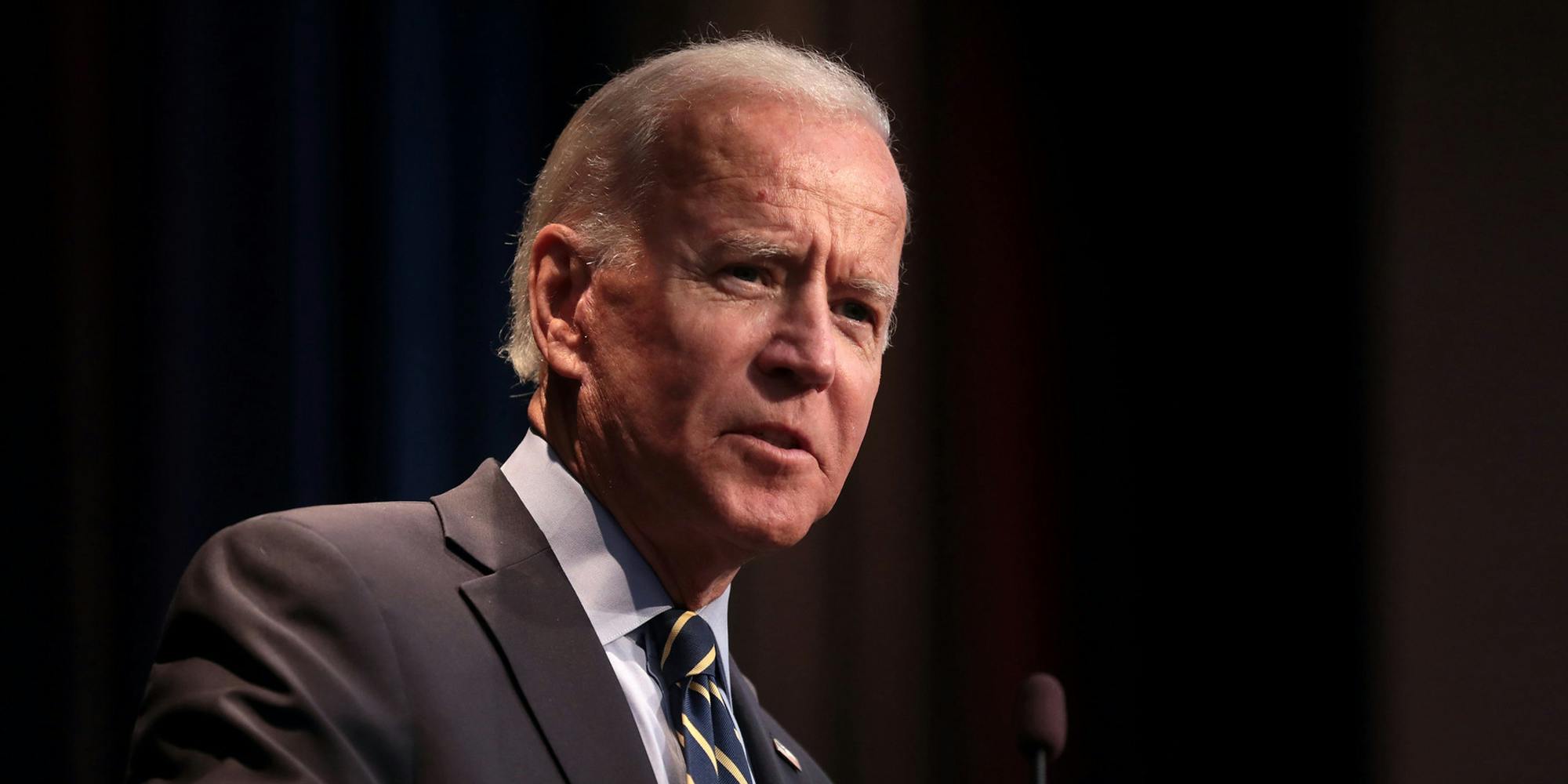 President Joe Biden speaking into a microphone.