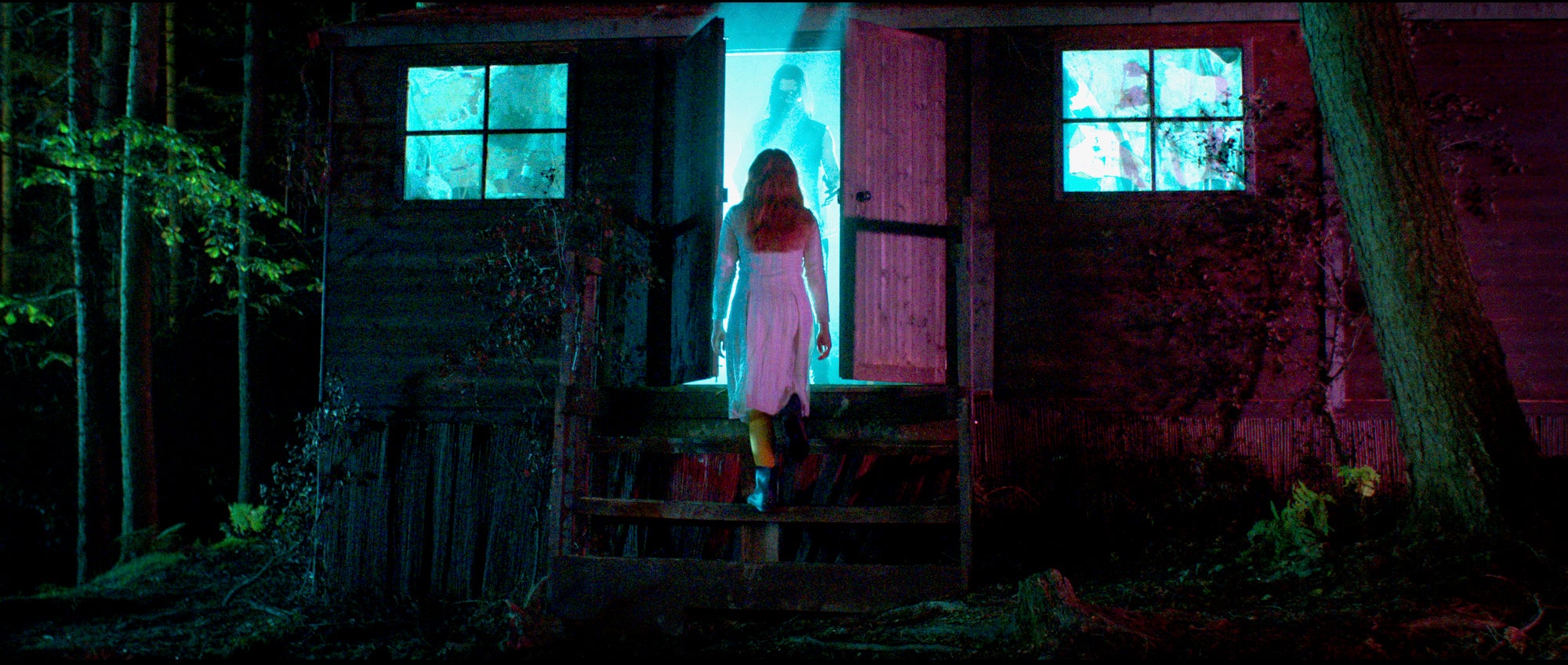 woman in white walking into house