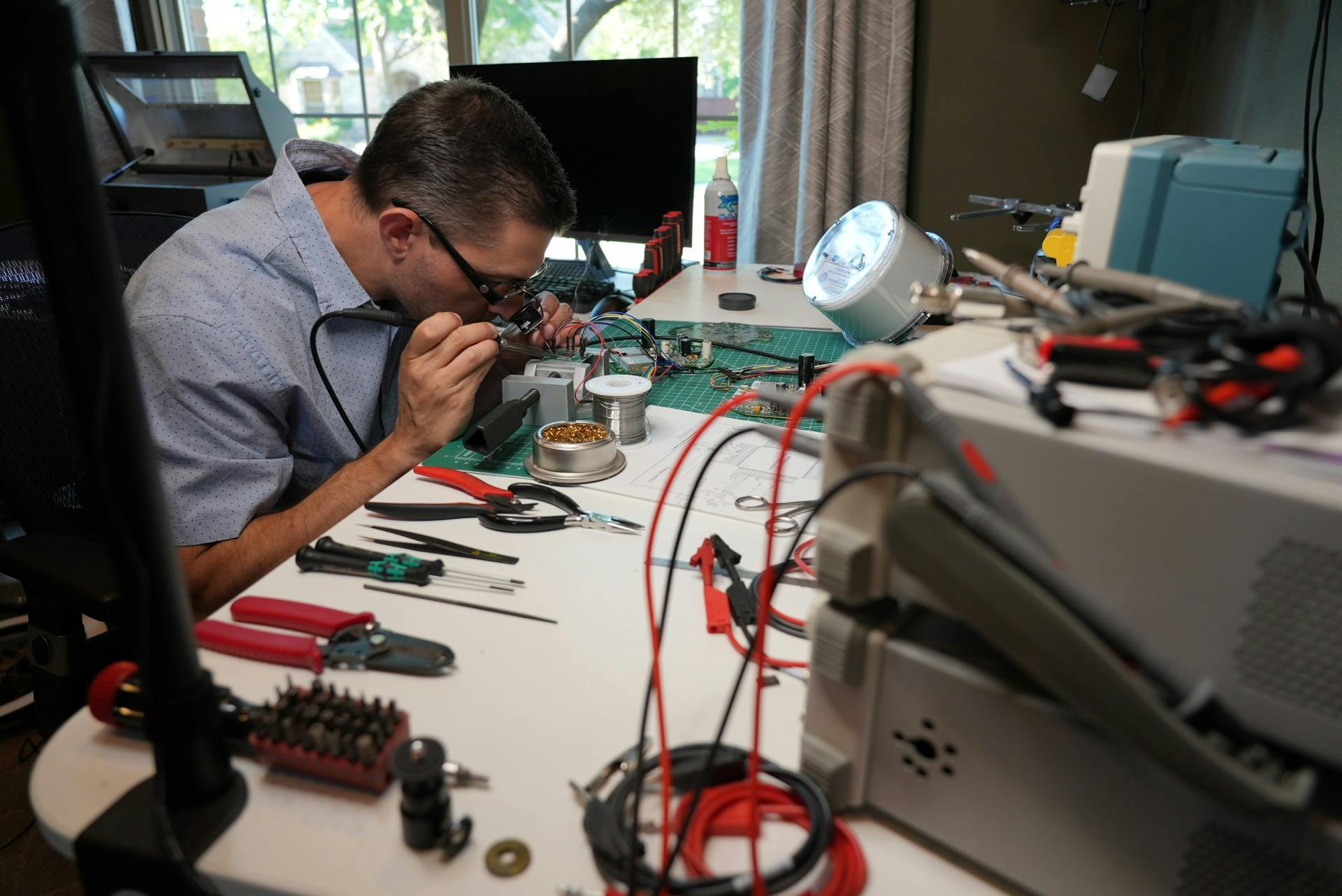 A man soldering at a desk