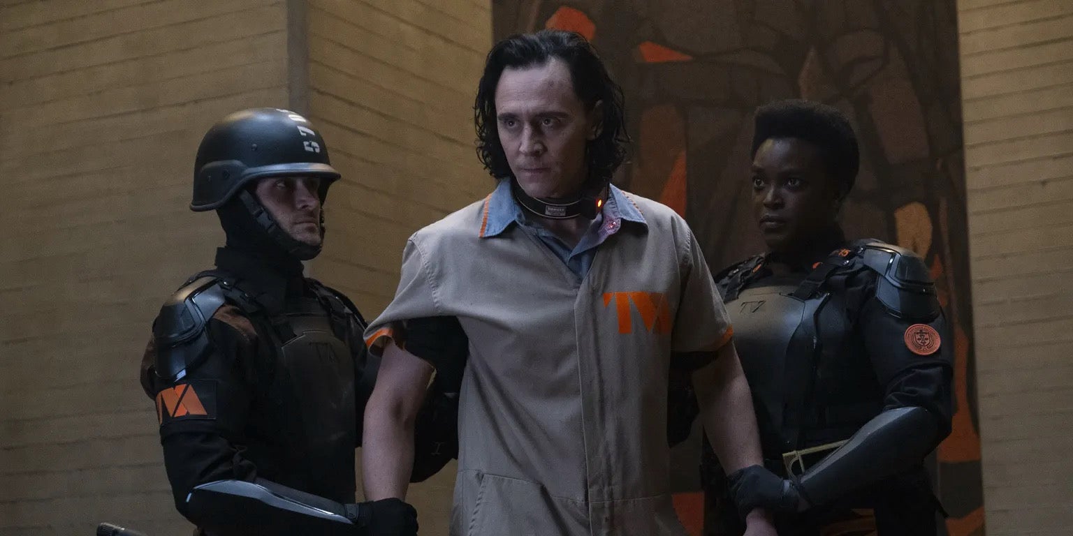 loki (center) led away by tva agents