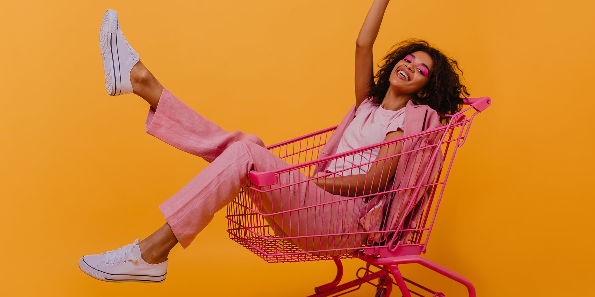 Young woman in shopping cart, smiling