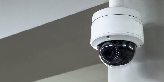 A surveillance camera with face recognition system attached to a wall.