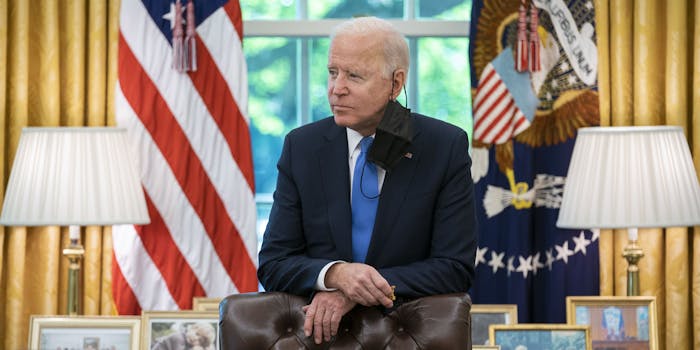 President Joe Biden looking off to the right inside the Oval Office.