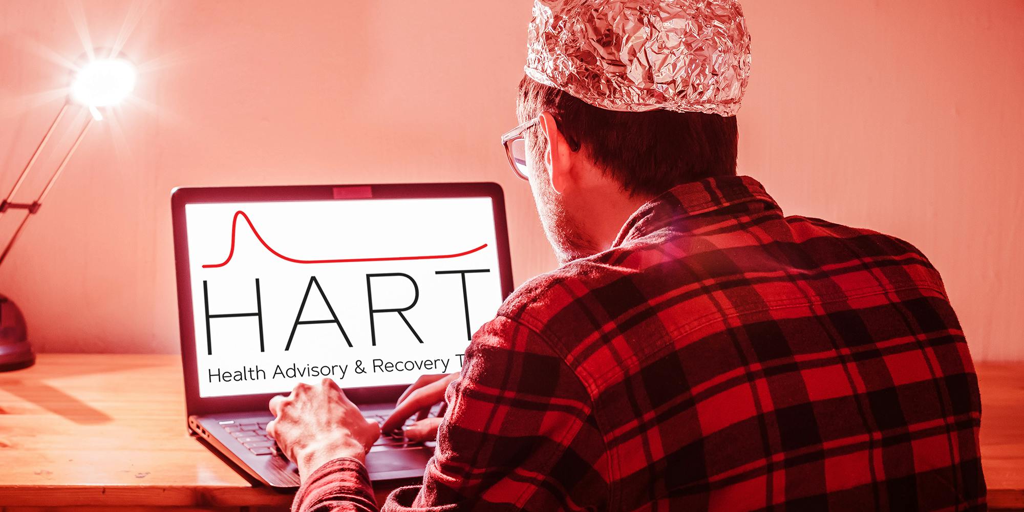 man with aluminum cap with HART Health Advisory & Recovery Team logo on laptop