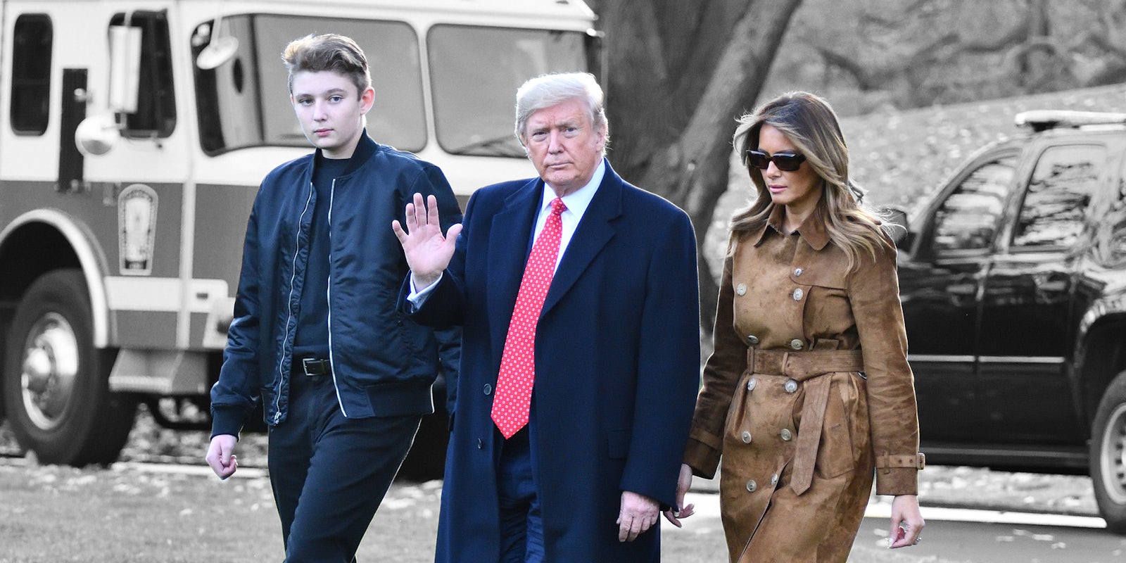 Donald Trump waves as he walks with First Lady Melania Trump and their son Barron