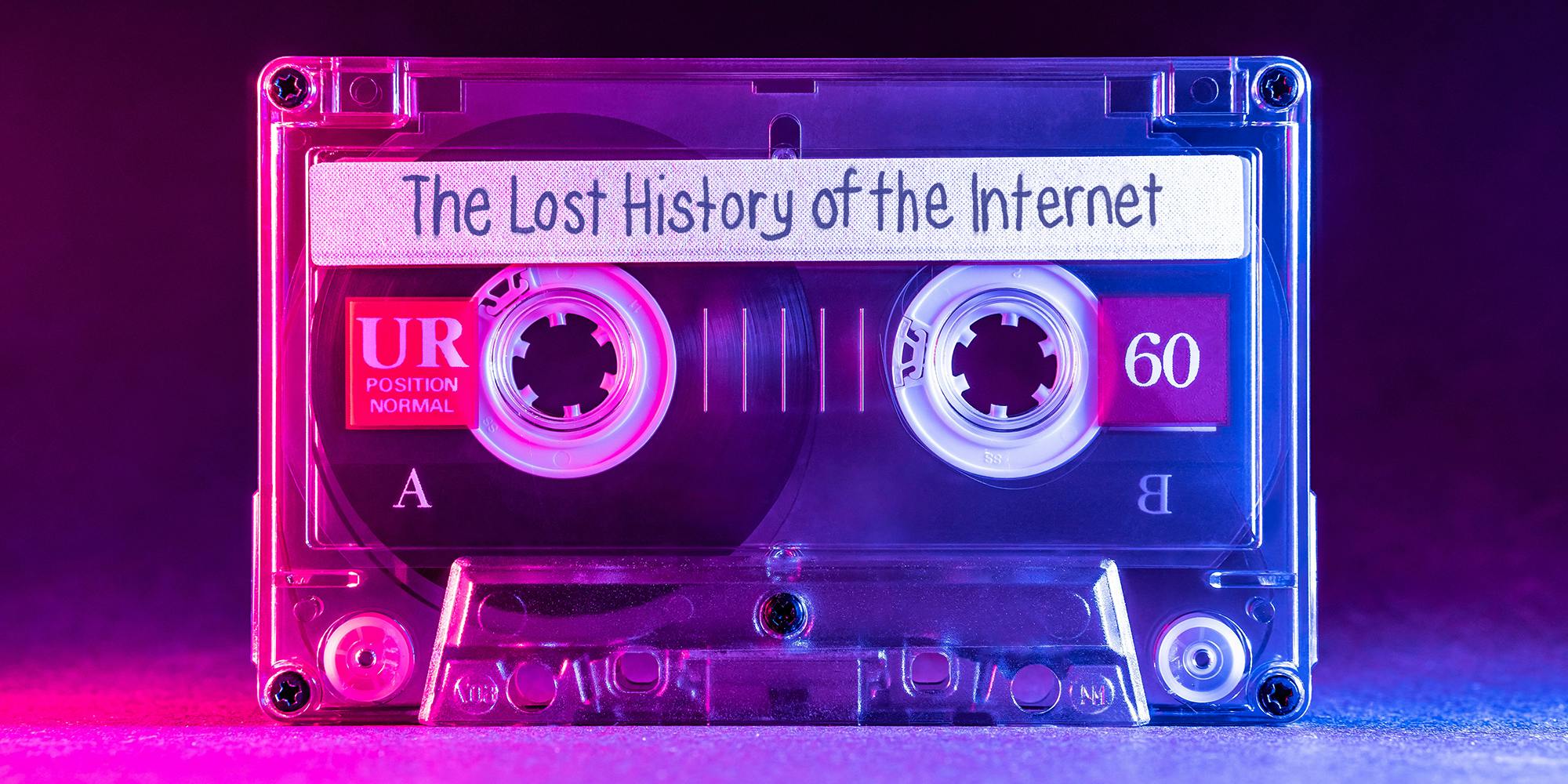 Transparent audio cassette tape lit by pink and blue lamps on a black background with "The Lost History of the Internet" written on the label.