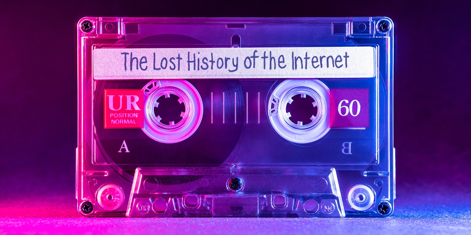 Transparent audio cassette tape lit by pink and blue lamps on a black background with 'The Lost History of the Internet' written on the label.