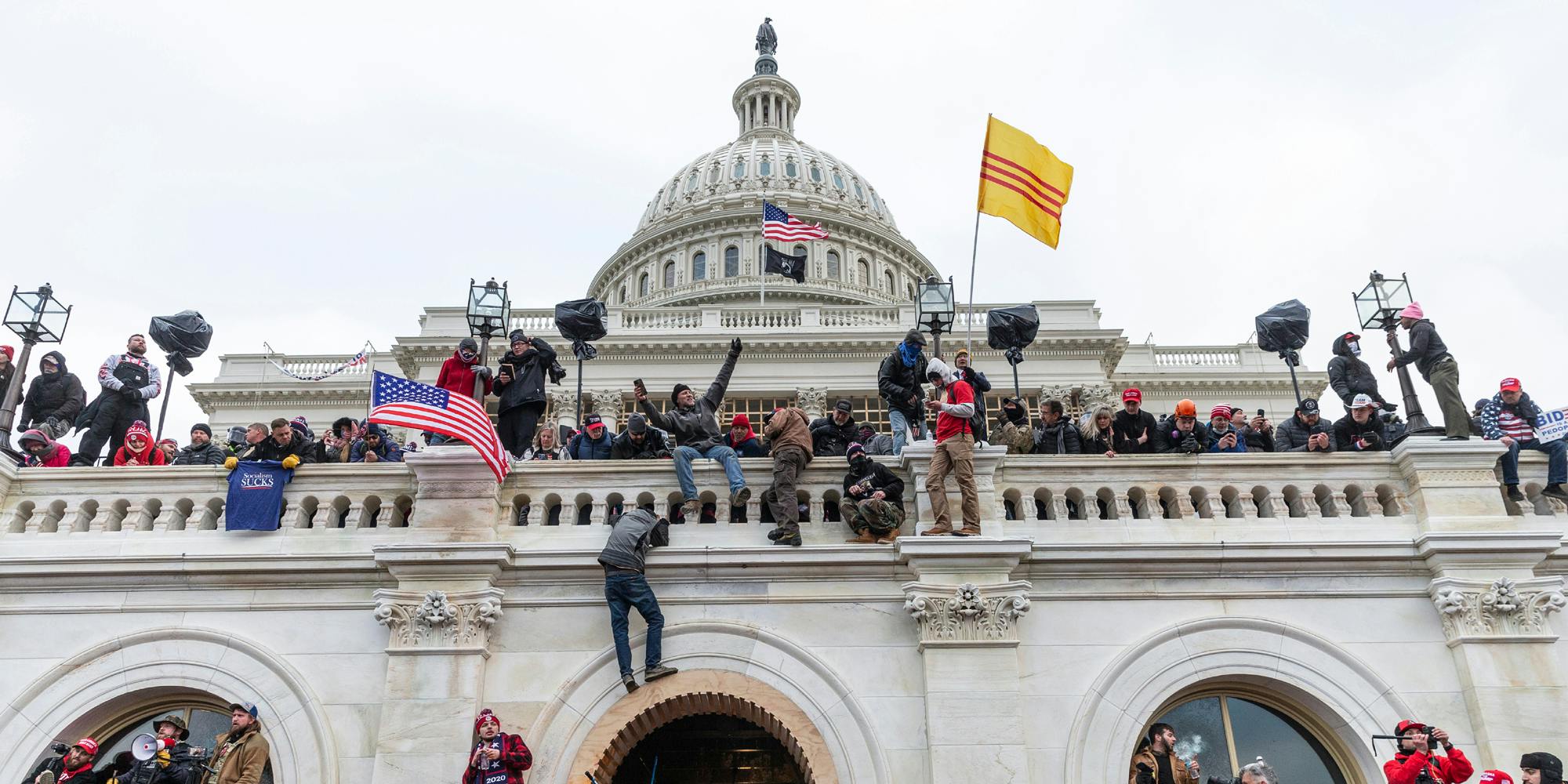 A photo from the January 6 capitol riot showing Trump supporters climbing the Capitol.