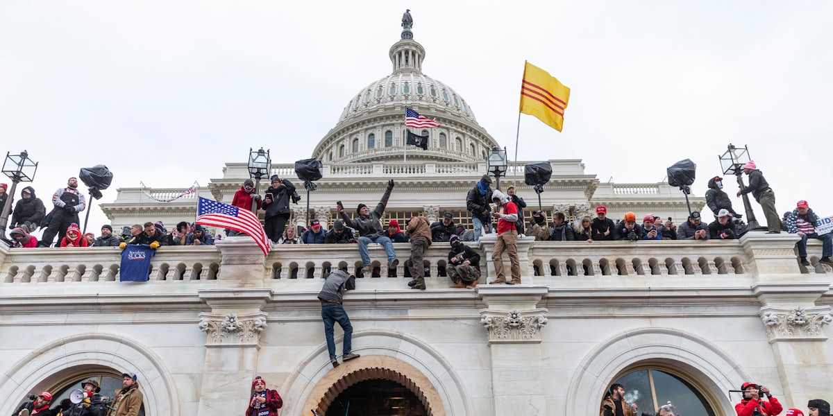 A photo from the January 6 capitol riot showing Trump supporters climbing the Capitol.