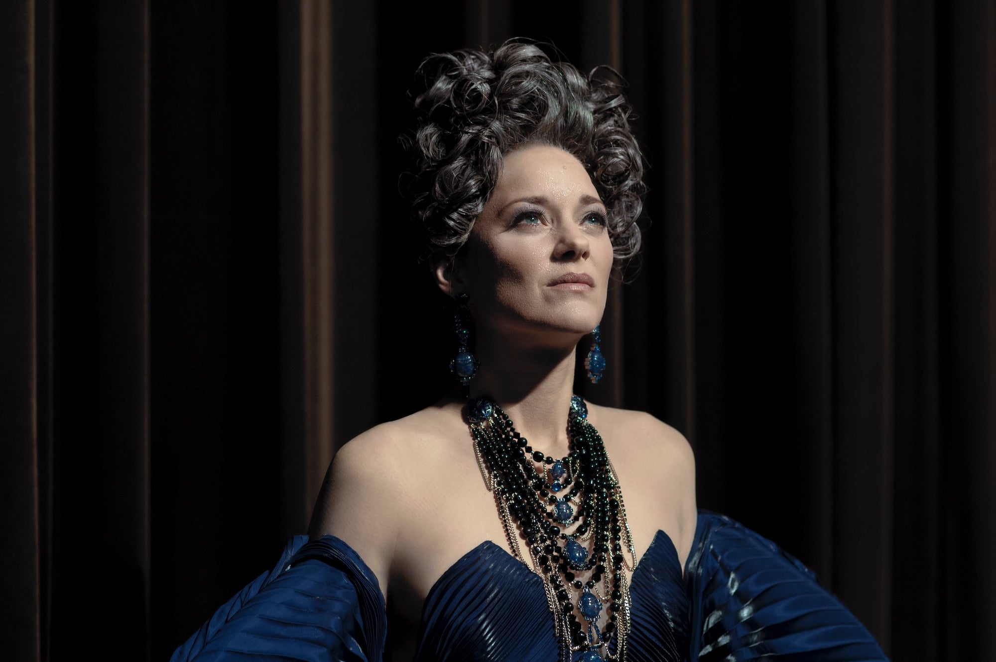 opera singer in blue dress listening for applause