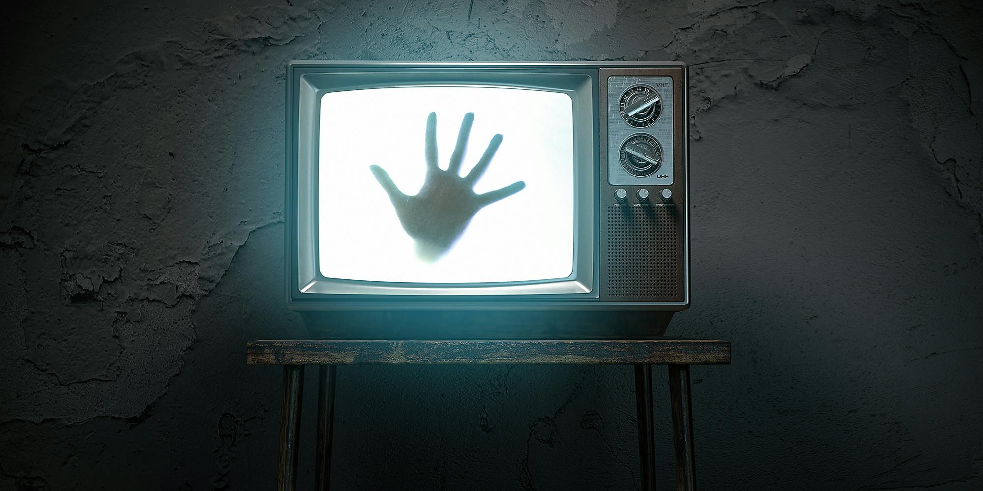 A hand coming out of a television.