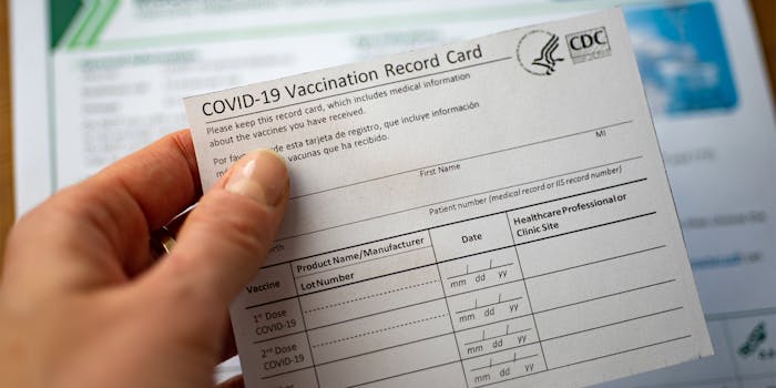 hand holding COVID-19 vaccination card