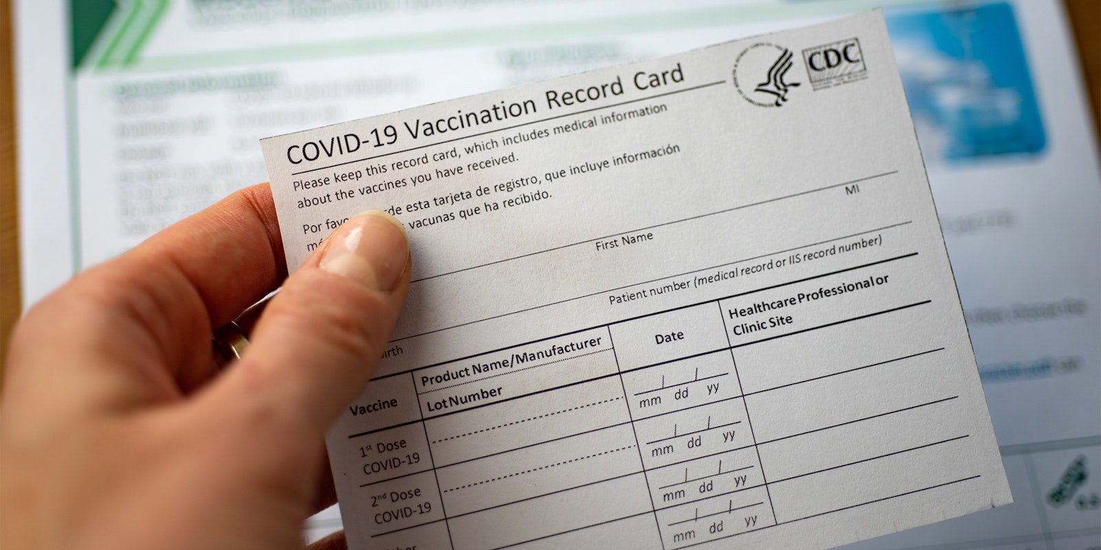 hand holding COVID-19 vaccination card