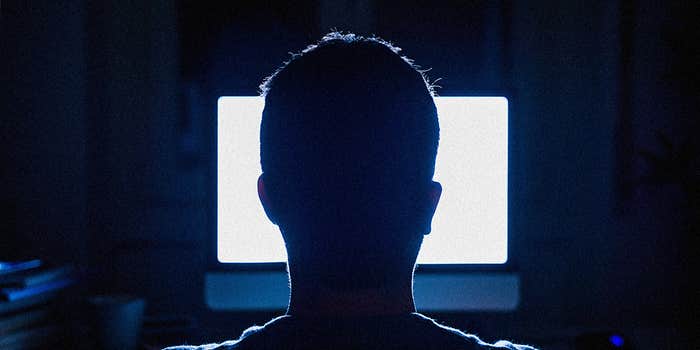 A man at a glowing computer screen.