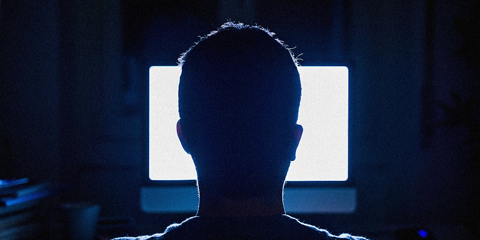 A man at a glowing computer screen.