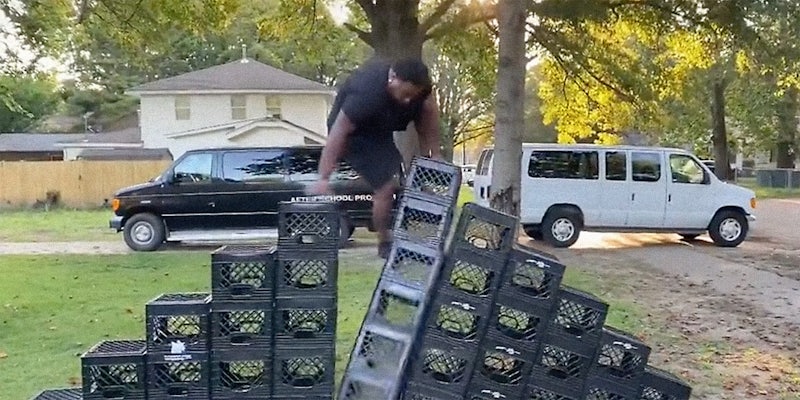 A man climbing a pile of milk crates.