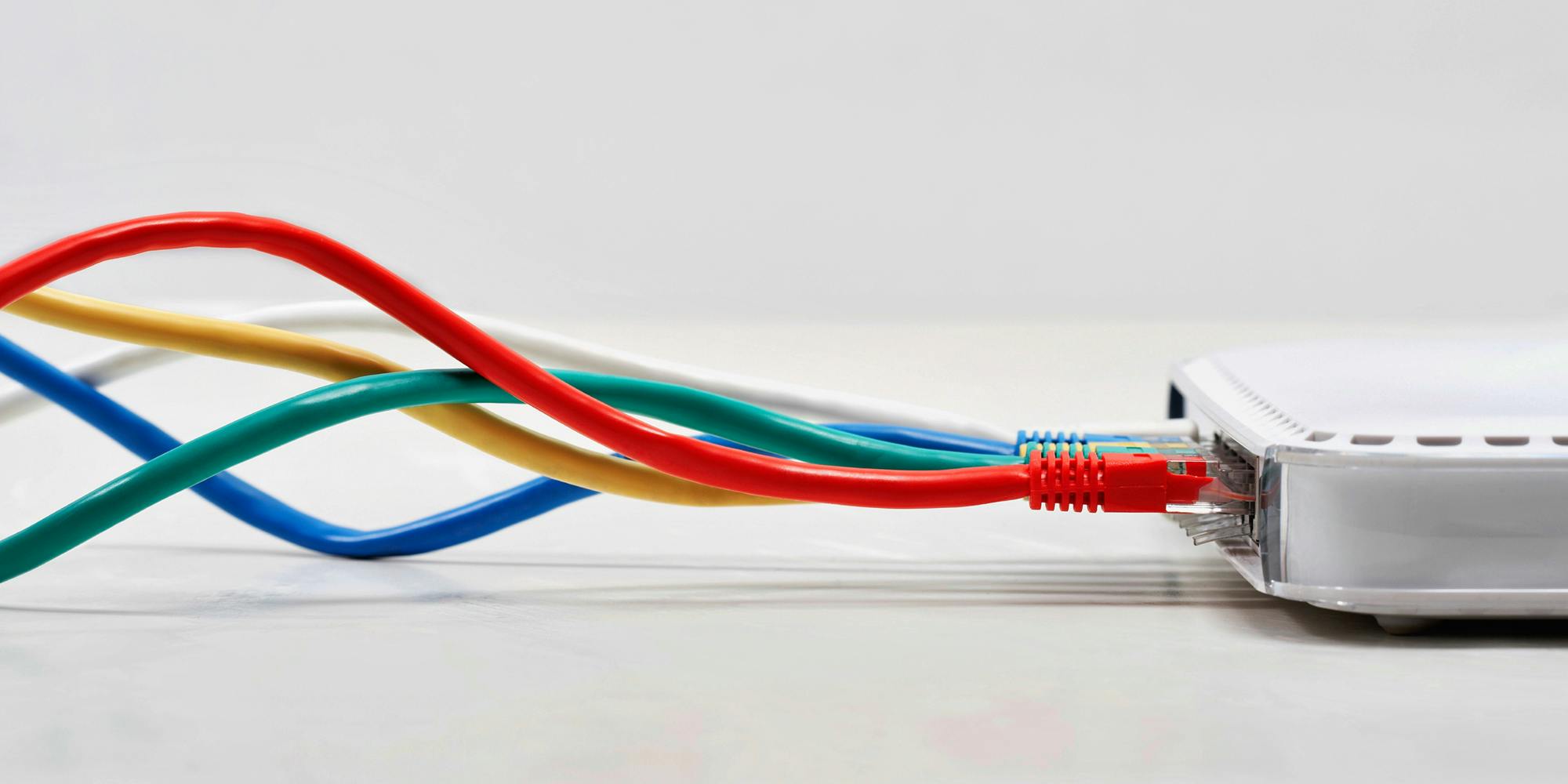 A router with several ethernet cables delivering broadband internet plugged into it.