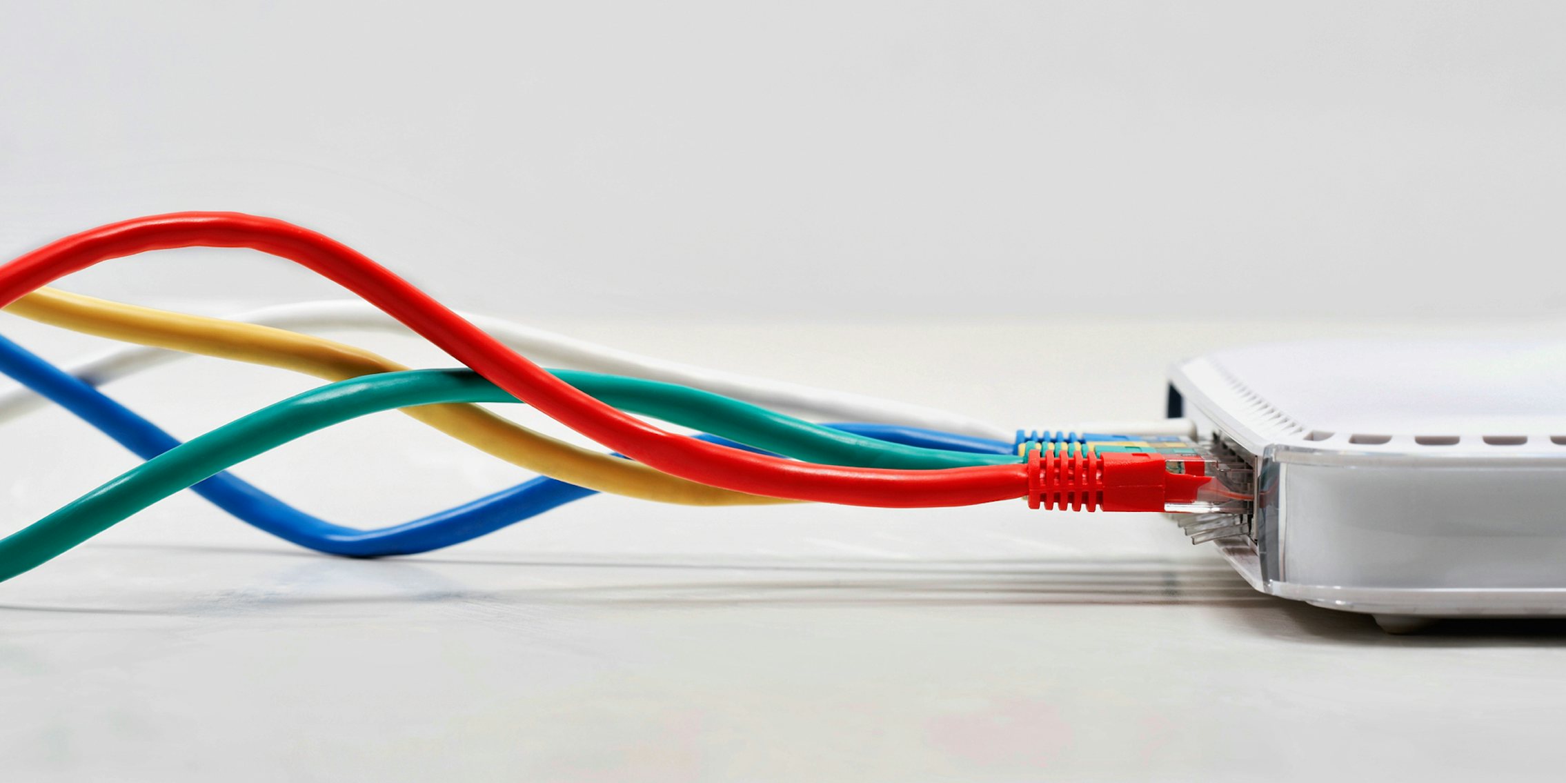 A router with several ethernet cables delivering broadband internet plugged into it.