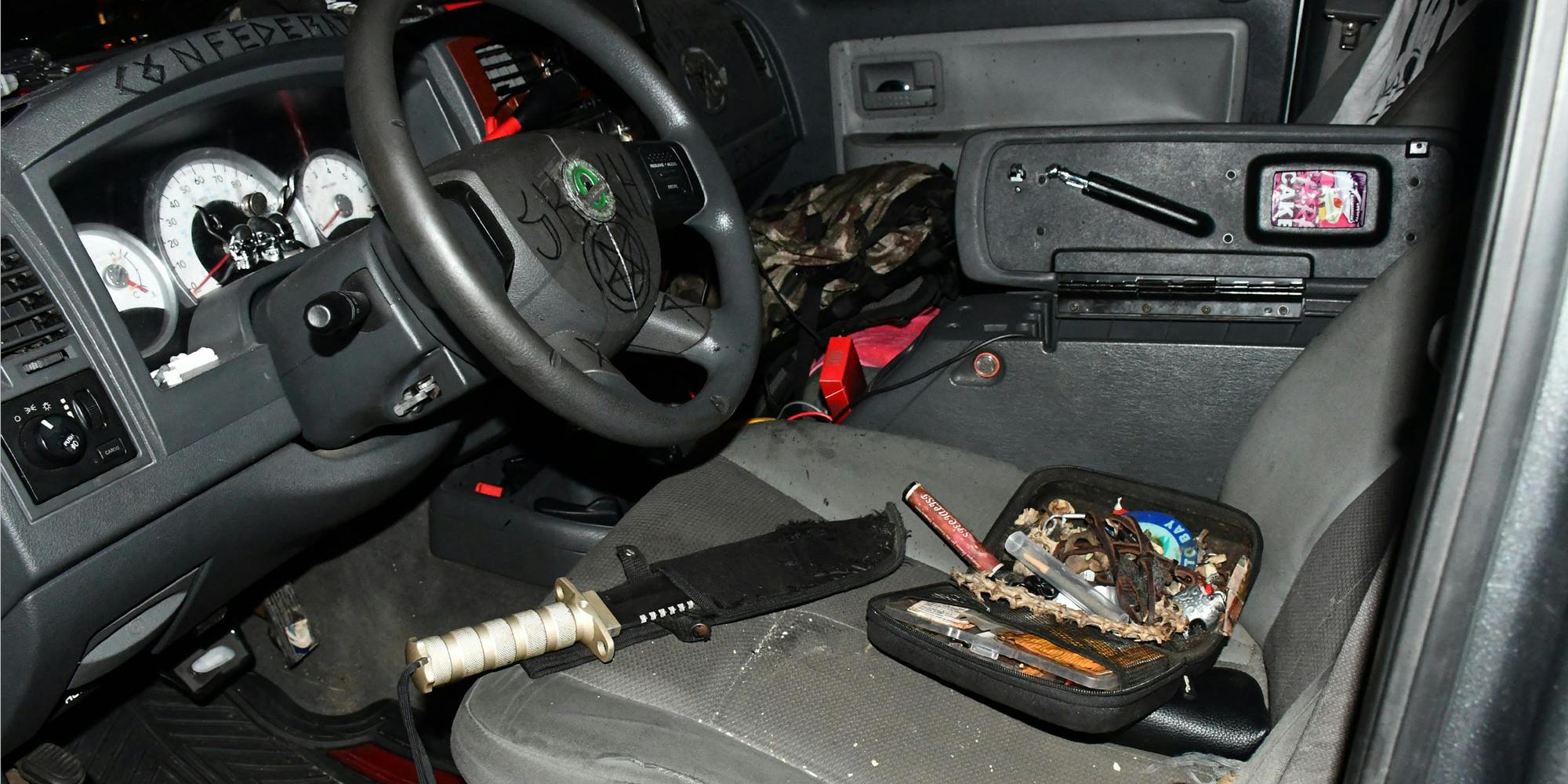 A photo from the U.S. Capitol Police showing the interior of a car belonging to a man who was arrested. The car has hate symbols drawn on it and knives inside.