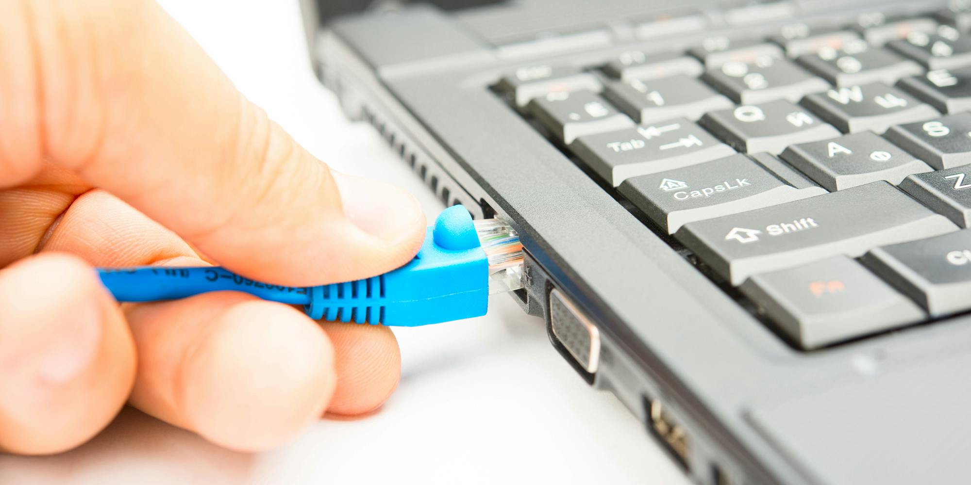 A person connecting to broadband internet through an ethernet cable.