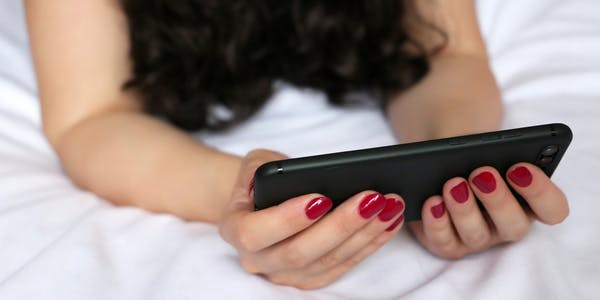 A woman browses porn on TikTok using her phone