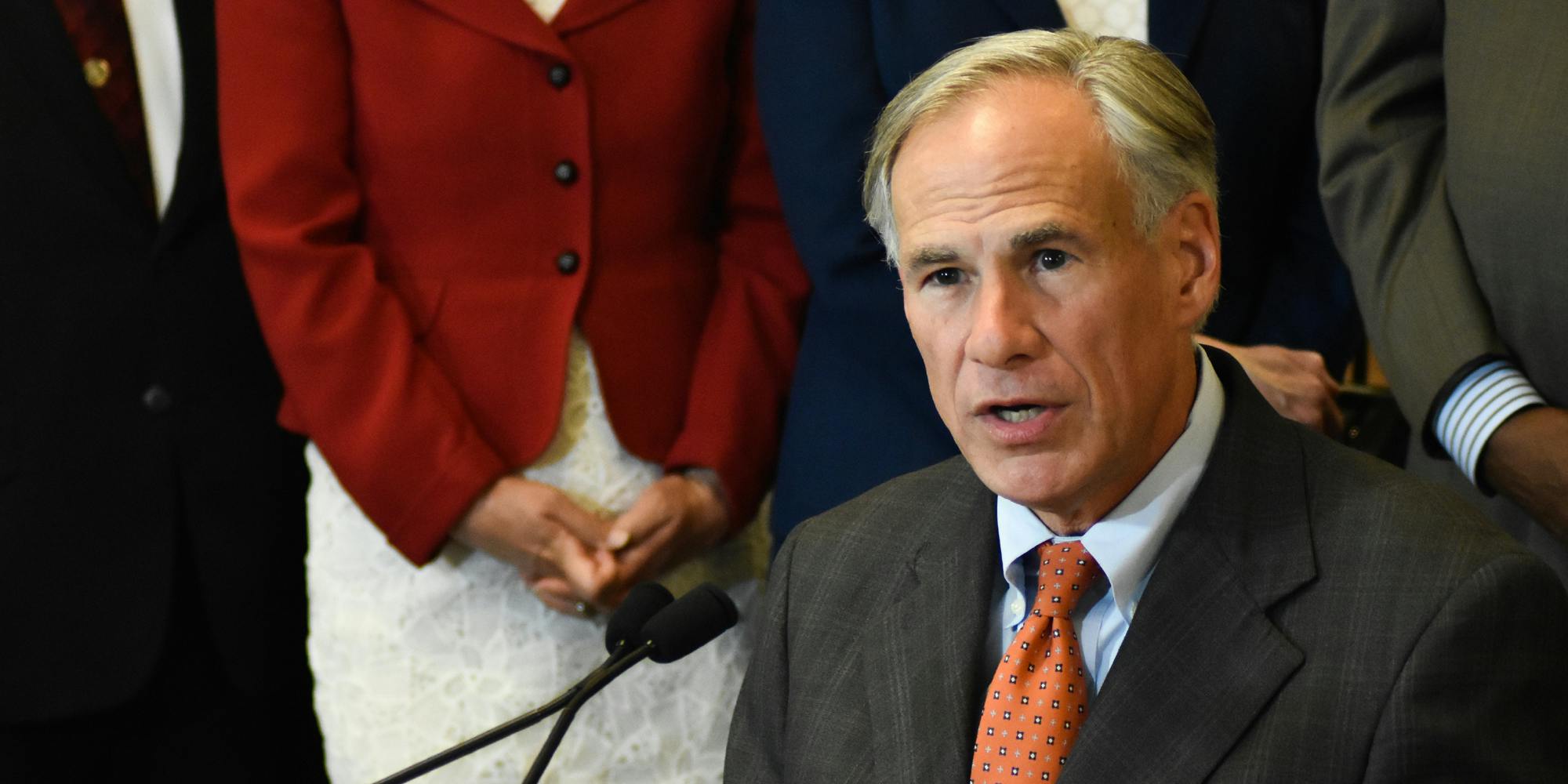 Texas Governor Greg Abbott speaking into a microphone.