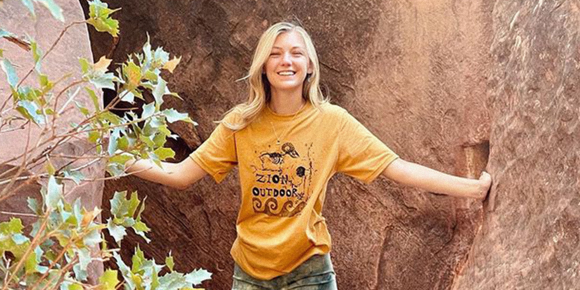 Young woman wearing "Zion outdoor" t-shirt between rocks