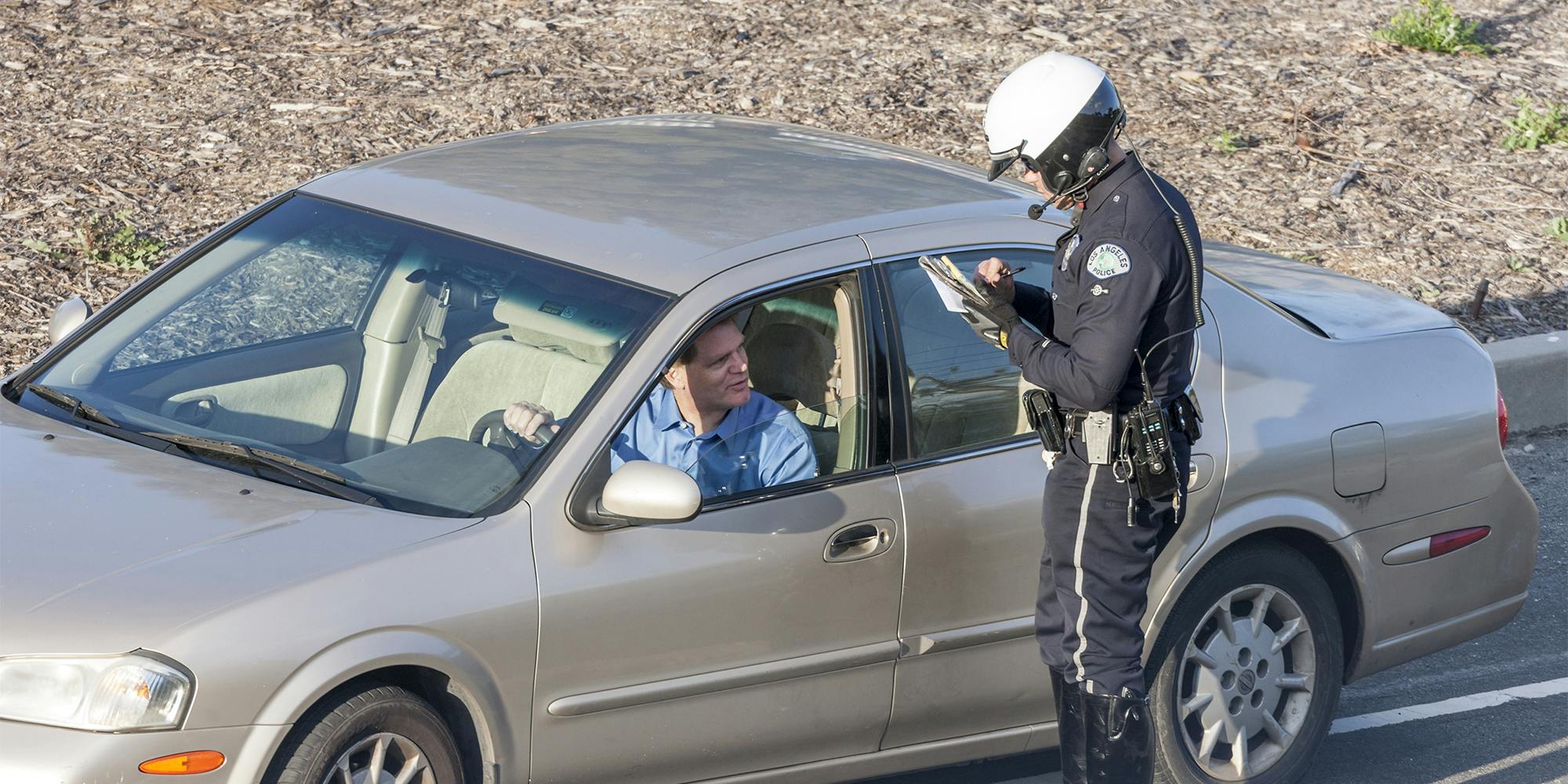 Los Angeles Police Department Police officer issuing a driver with a citation (ticket) for driving offences.