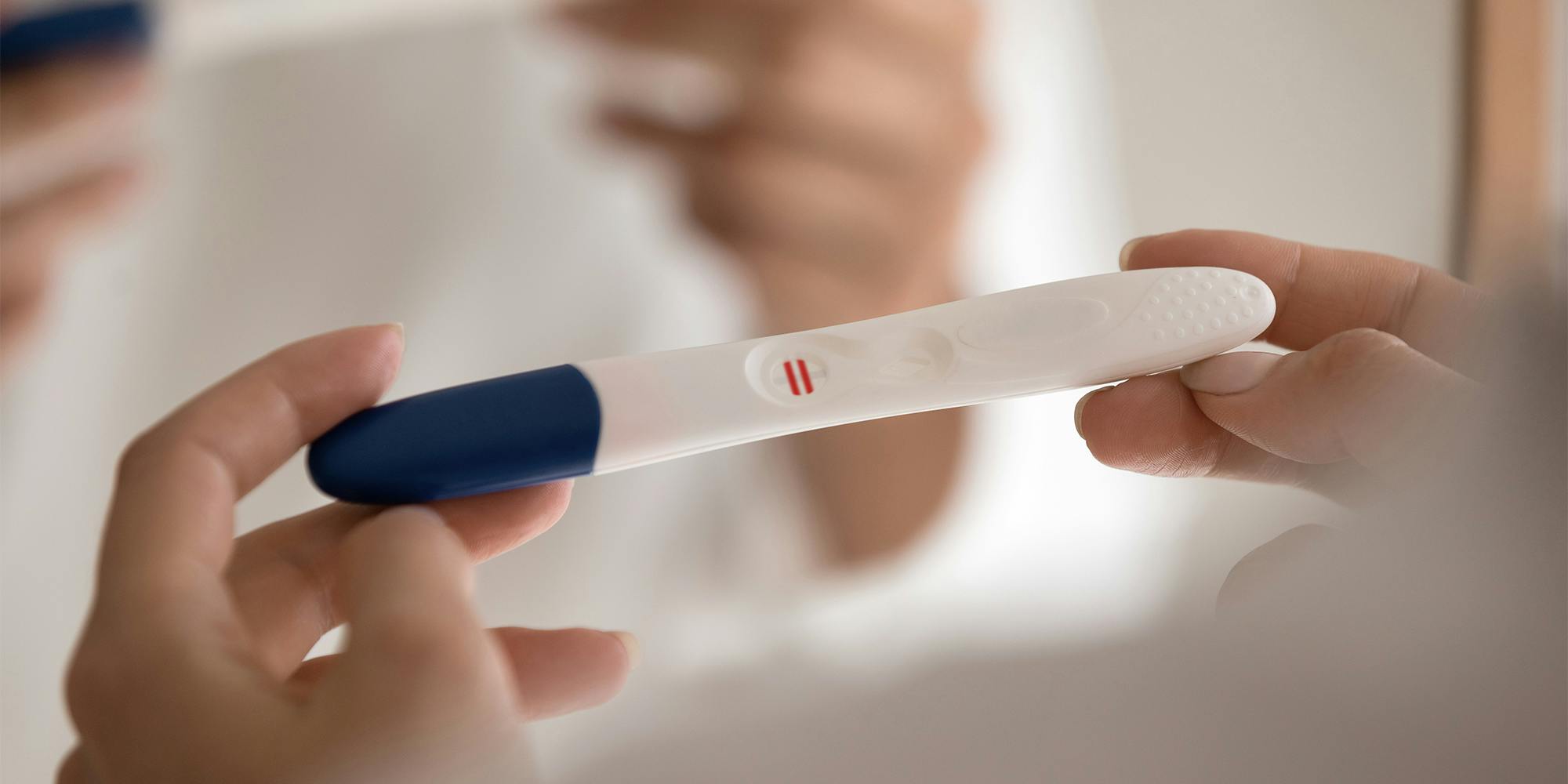 Woman holding pregnancy test