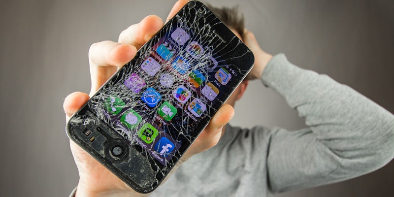 man holding smashed iphone